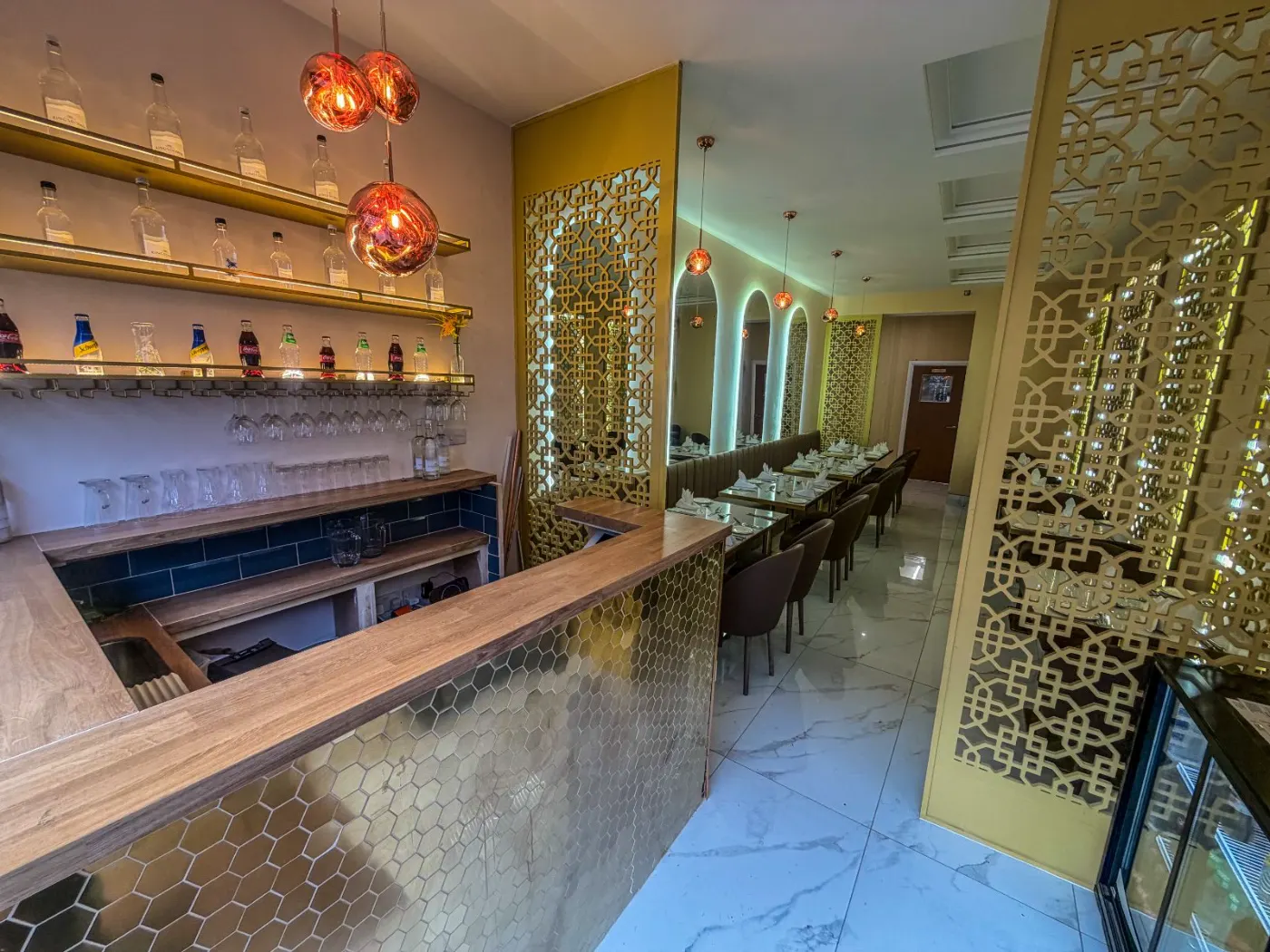 Restaurant bar area and dining room with marble-effect porcelain floor tiles in Streatham