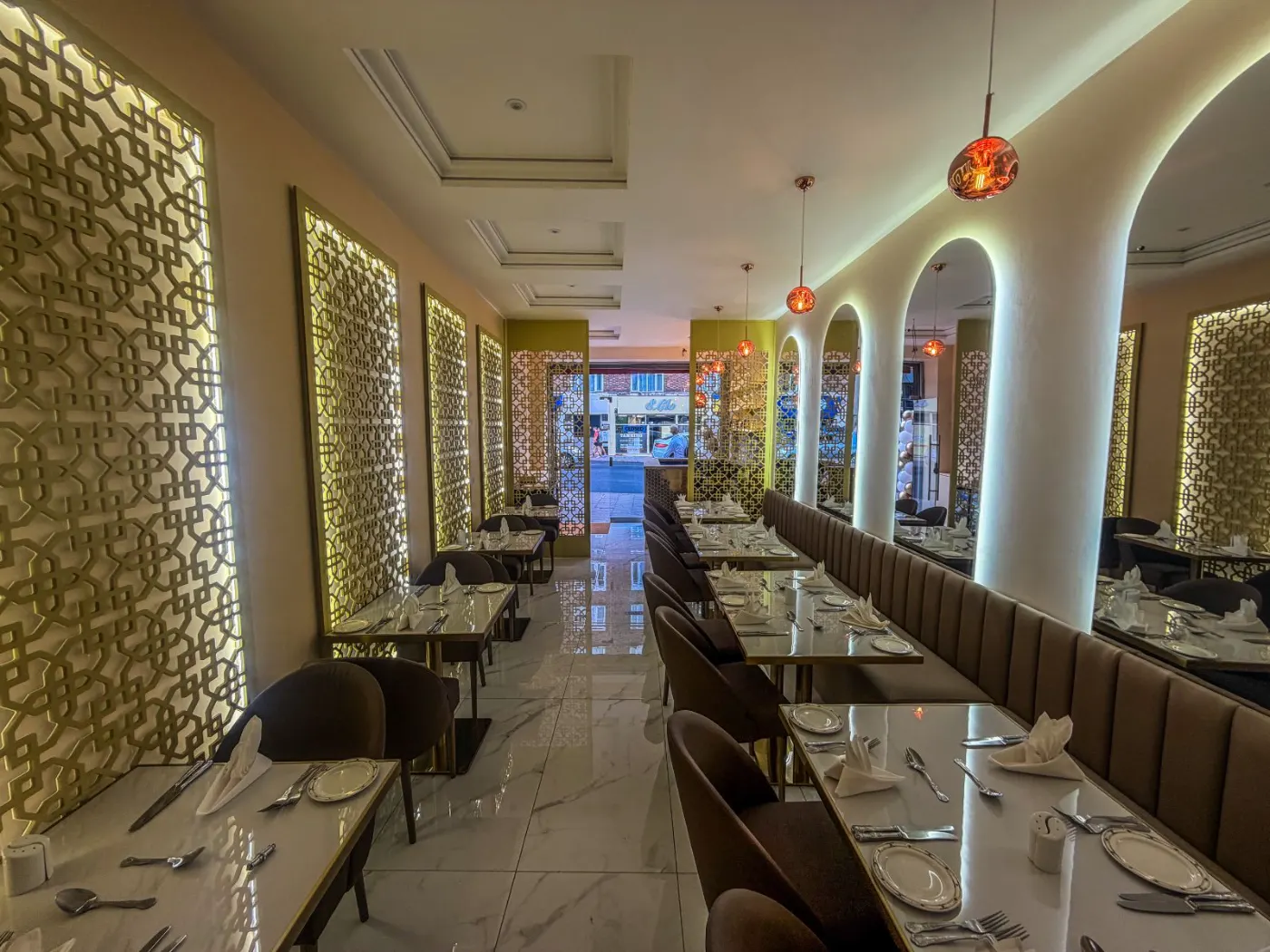 Restaurant fit-out in Streatham with backlit CNC-cut MDF panels, LED arched mirrors and marble-effect porcelain floor tiles